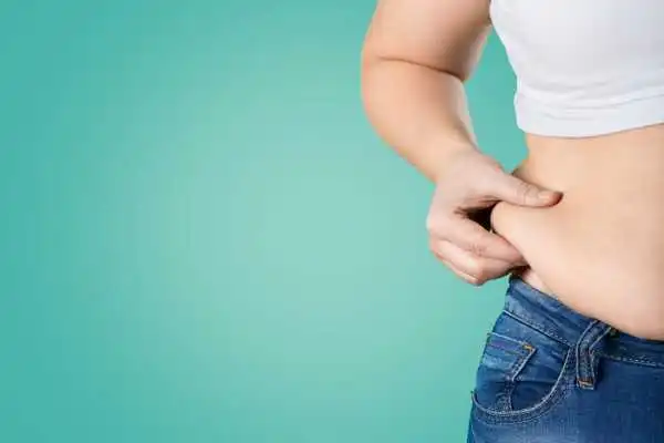 Image of woman pinching her love handles to show weight gain Bexleyhill